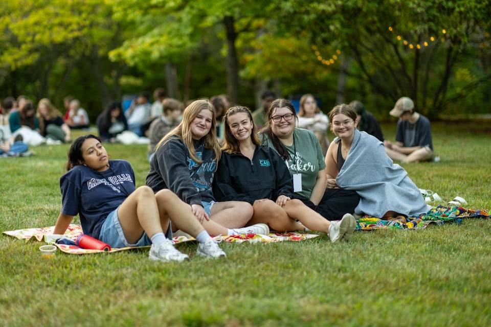 Students smiling while sitting on blankets